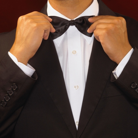 Man adjusting black bow tie