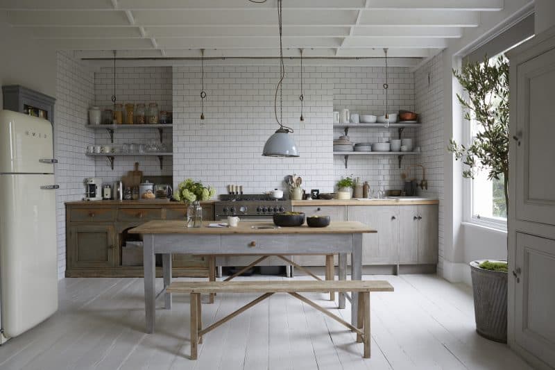 Neutral open plan kitchen diner, white wood beam ceiling, vintage rustic bench and table, fitted units, metro ceramic brick wall tiles, Smeg cooker, pendant light, painted floorboards L etc 02/2014