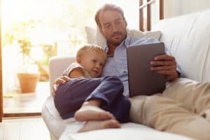 Father and son reading on digital tablet